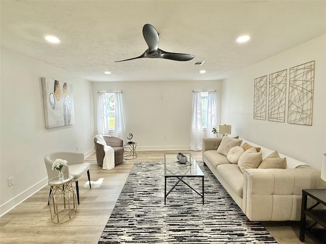 living room featuring ceiling fan and hardwood / wood-style floors