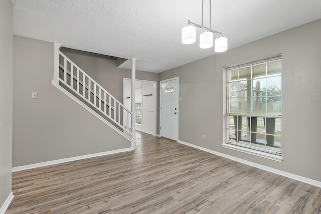 interior space with hardwood / wood-style floors, a notable chandelier, and a textured ceiling