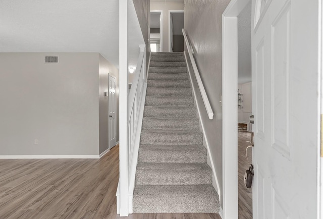 stairs with hardwood / wood-style flooring