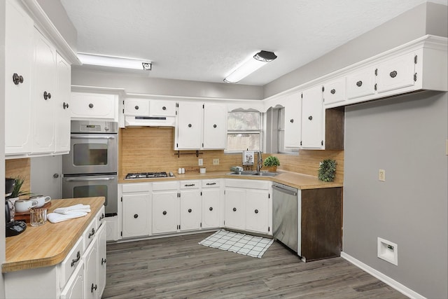 kitchen with white cabinets, backsplash, sink, and appliances with stainless steel finishes