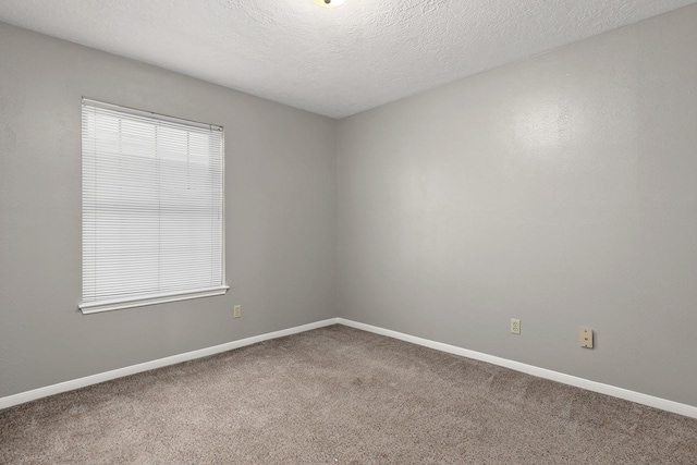 carpeted empty room featuring a textured ceiling