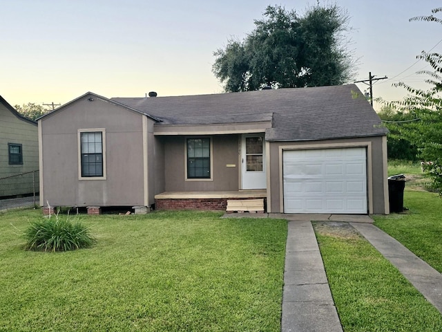 single story home featuring a lawn and a garage