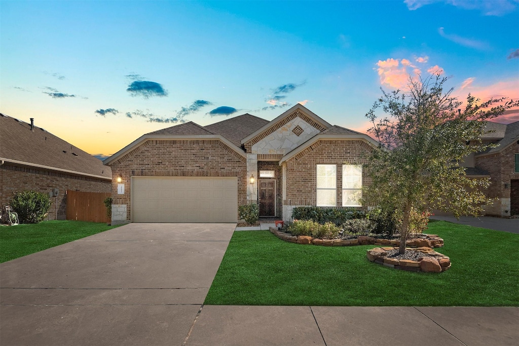 view of front facade featuring a garage and a lawn