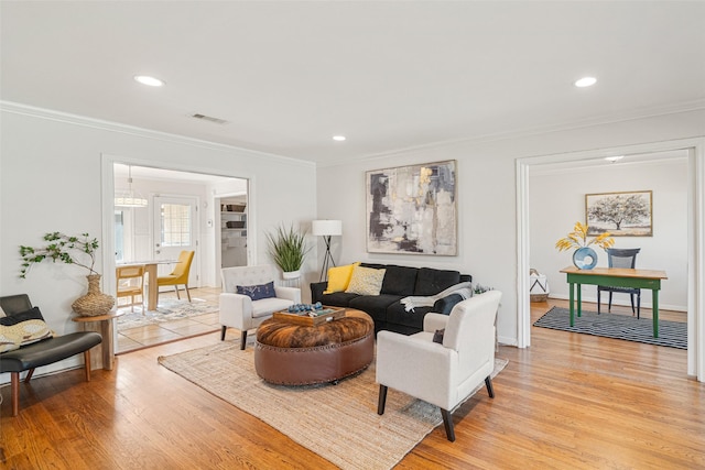 living room featuring light hardwood / wood-style flooring and crown molding