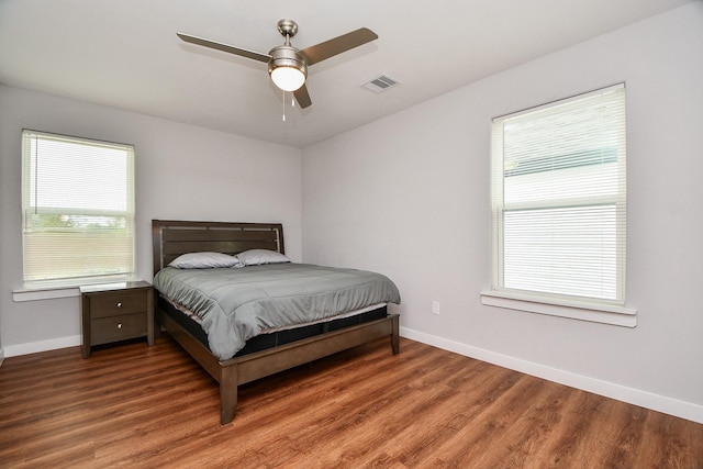 bedroom featuring baseboards, visible vents, ceiling fan, and wood finished floors