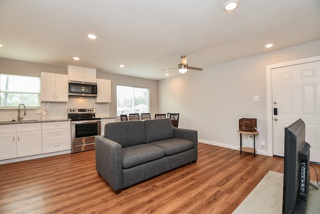 living area featuring recessed lighting, baseboards, and light wood finished floors