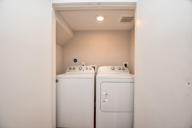 washroom featuring laundry area, washing machine and dryer, and visible vents