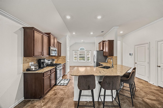 kitchen with light stone counters, kitchen peninsula, backsplash, appliances with stainless steel finishes, and sink