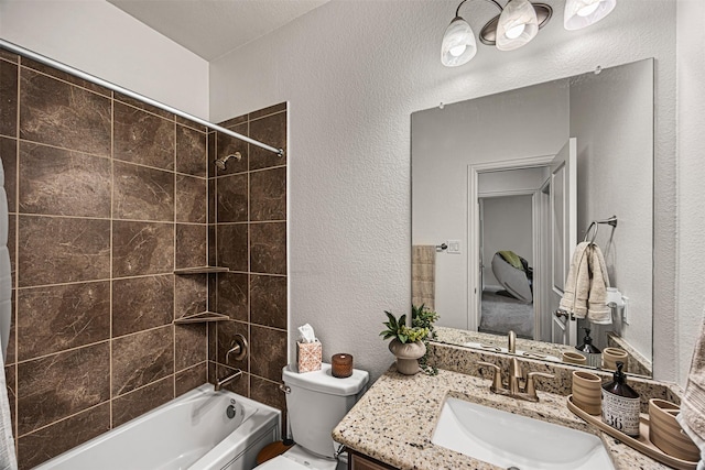 full bathroom featuring toilet, vanity, and tiled shower / bath