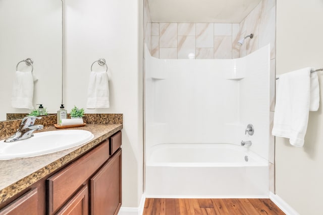 bathroom featuring hardwood / wood-style flooring, vanity, and  shower combination