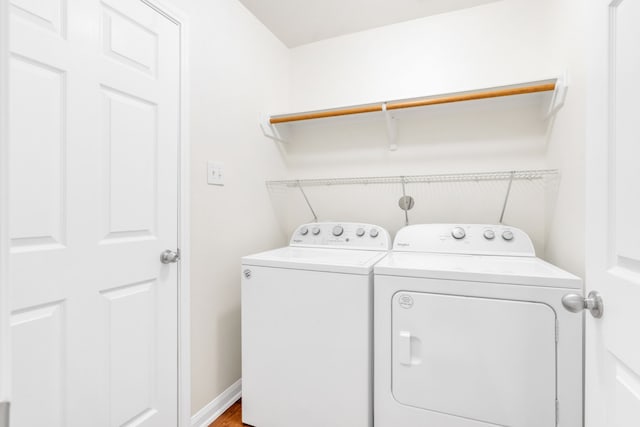 clothes washing area with washer and dryer and hardwood / wood-style flooring