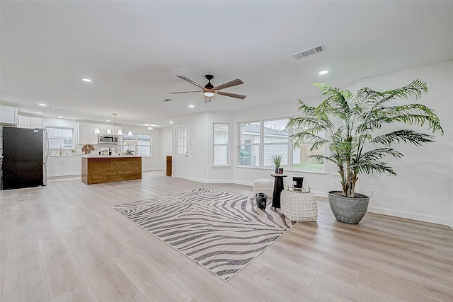 living room featuring ceiling fan and light wood-type flooring