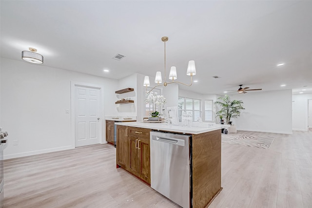 kitchen featuring pendant lighting, a center island, ceiling fan with notable chandelier, stainless steel dishwasher, and light wood-type flooring