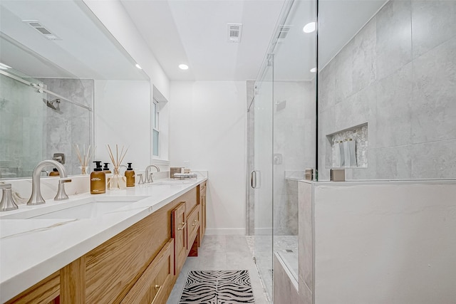 bathroom with tile patterned floors, vanity, and a shower with door