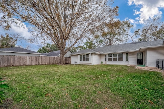 rear view of property featuring a lawn