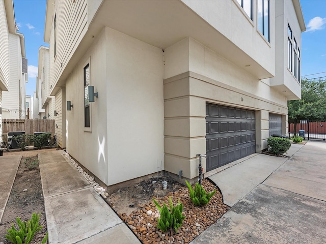 view of property exterior featuring central air condition unit and a garage