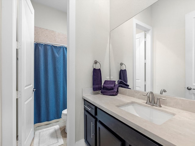 bathroom featuring a shower with shower curtain, vanity, and toilet