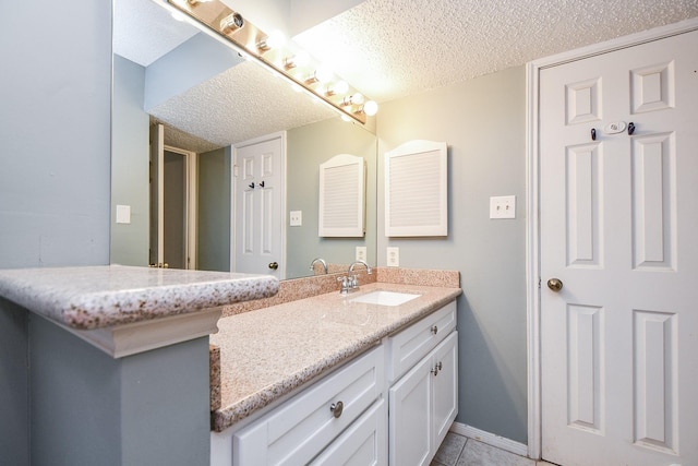 bathroom featuring tile patterned floors, vanity, and a textured ceiling