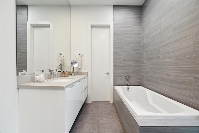 bathroom with tiled bath, tile walls, tile patterned floors, and vanity