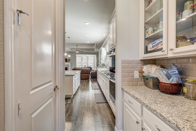 kitchen with pendant lighting, dark hardwood / wood-style floors, white cabinetry, and tasteful backsplash