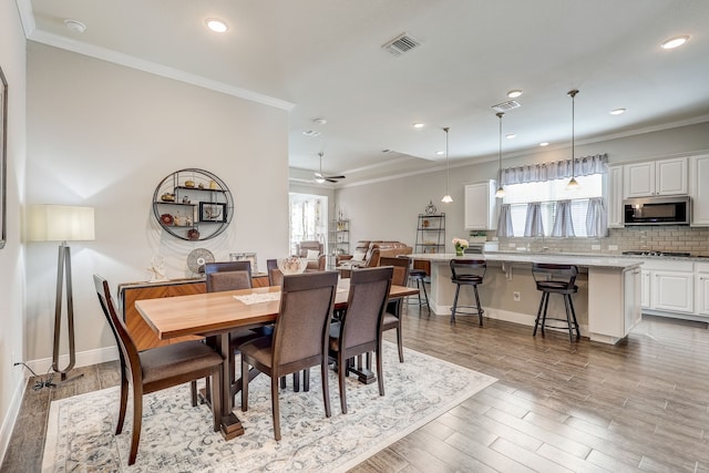 dining space featuring hardwood / wood-style flooring, ceiling fan, and ornamental molding