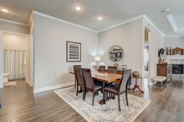 dining space featuring a high end fireplace and ornamental molding