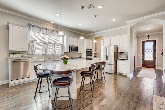 kitchen with white cabinetry, a center island, stainless steel appliances, and decorative light fixtures