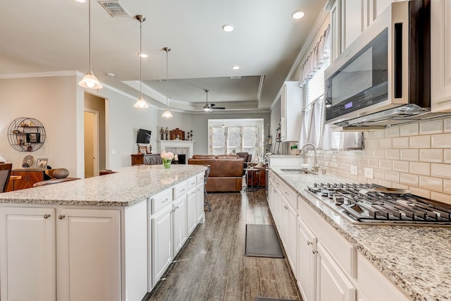 kitchen with white cabinets, pendant lighting, a center island, and stainless steel appliances