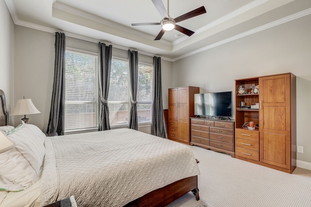 carpeted bedroom with ceiling fan, a raised ceiling, and ornamental molding