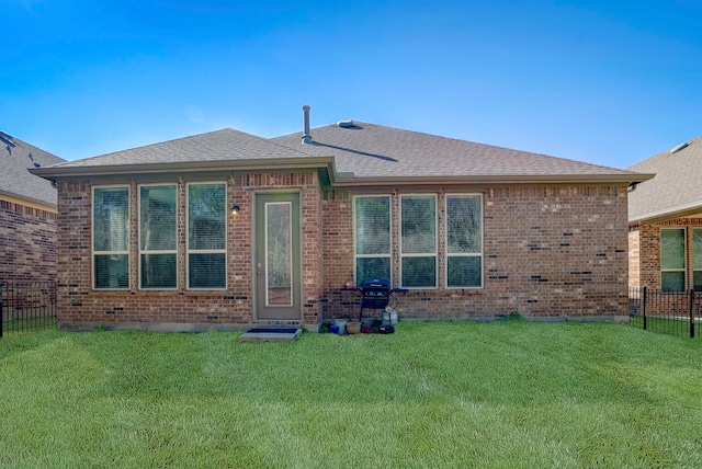 rear view of house featuring a lawn