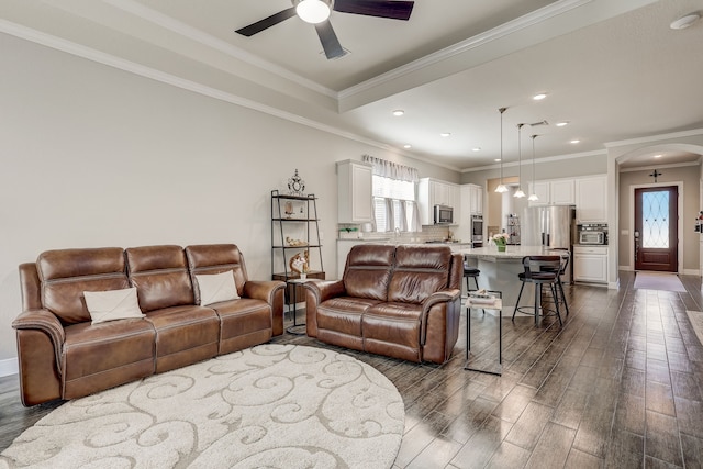 living room featuring ceiling fan, dark hardwood / wood-style flooring, and ornamental molding