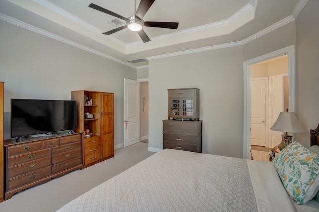 bedroom featuring ceiling fan, crown molding, light carpet, and a tray ceiling