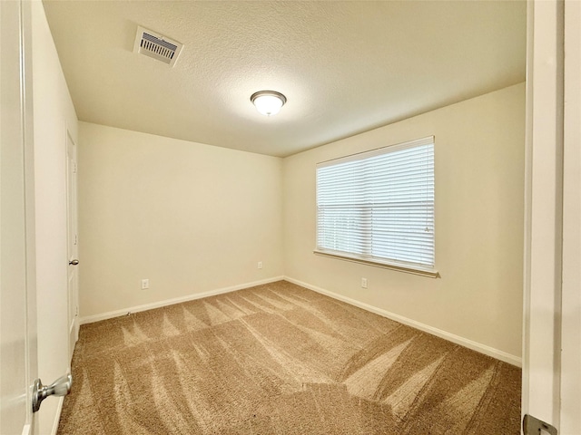 spare room featuring carpet flooring and a textured ceiling