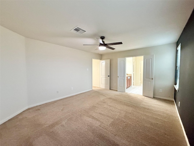 unfurnished bedroom with ceiling fan, ensuite bathroom, and light colored carpet