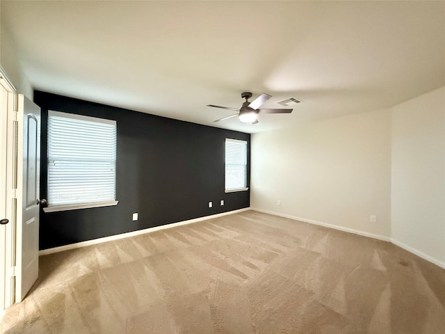 empty room featuring light colored carpet and ceiling fan