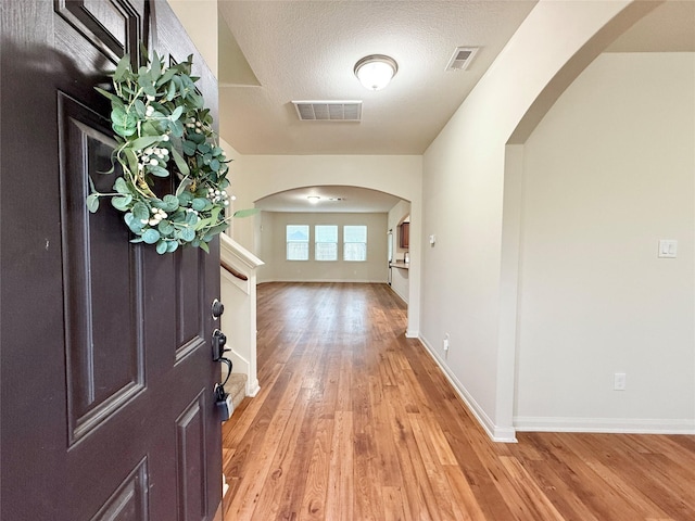 entrance foyer with a textured ceiling and light wood-type flooring