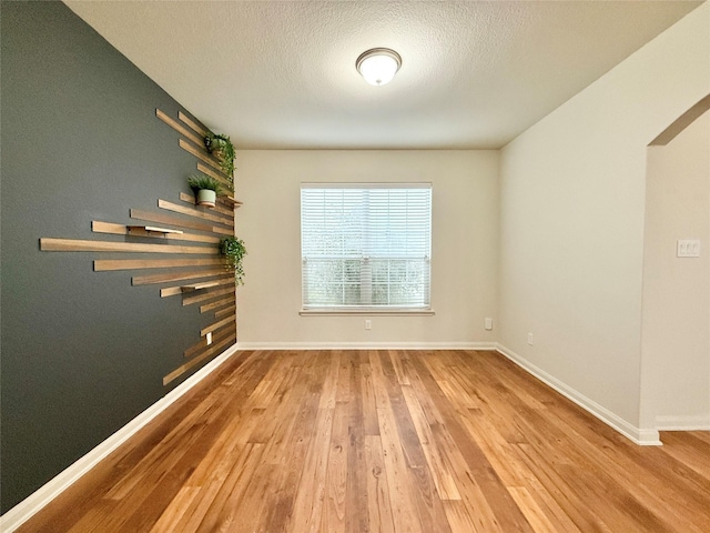 spare room featuring a textured ceiling and hardwood / wood-style flooring