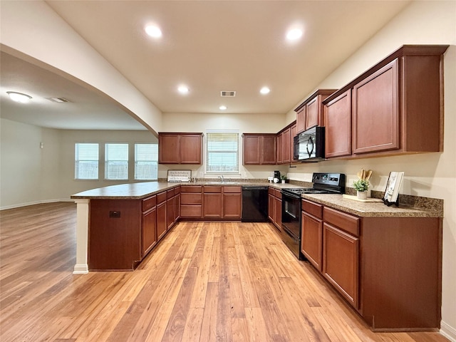 kitchen featuring kitchen peninsula, sink, light hardwood / wood-style floors, and black appliances