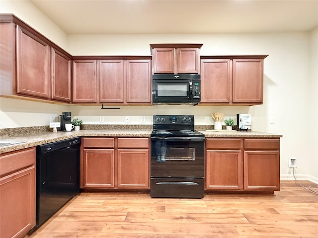 kitchen with black appliances and light hardwood / wood-style floors