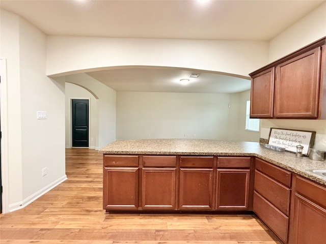 kitchen featuring kitchen peninsula and light hardwood / wood-style flooring