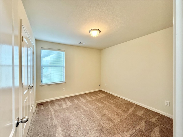 carpeted spare room featuring a textured ceiling