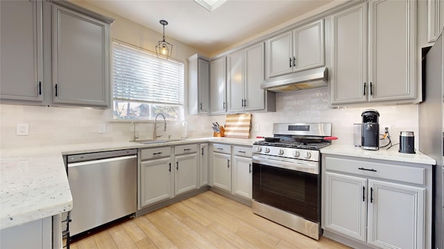 kitchen with gray cabinetry, sink, hanging light fixtures, tasteful backsplash, and stainless steel appliances