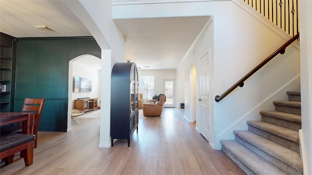 entrance foyer featuring light wood-type flooring and crown molding