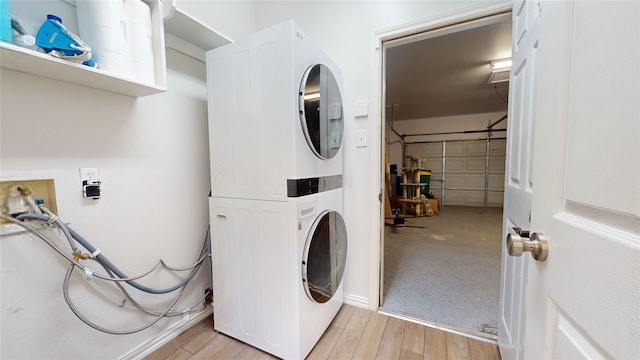 laundry room featuring stacked washer / drying machine and light wood-type flooring