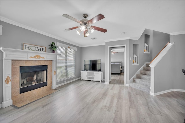 unfurnished living room featuring crown molding, a fireplace, and light hardwood / wood-style flooring