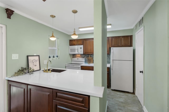kitchen featuring visible vents, a peninsula, white appliances, a sink, and backsplash