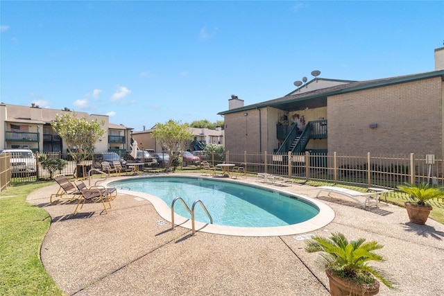 pool featuring fence, a residential view, and a patio area