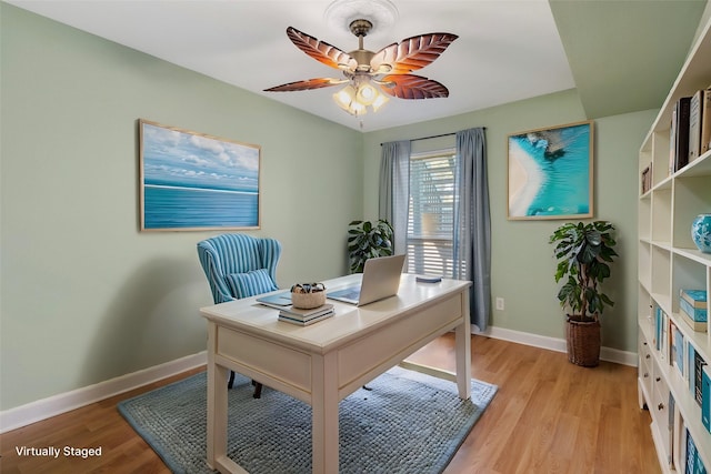 office area with baseboards, ceiling fan, and light wood-style flooring