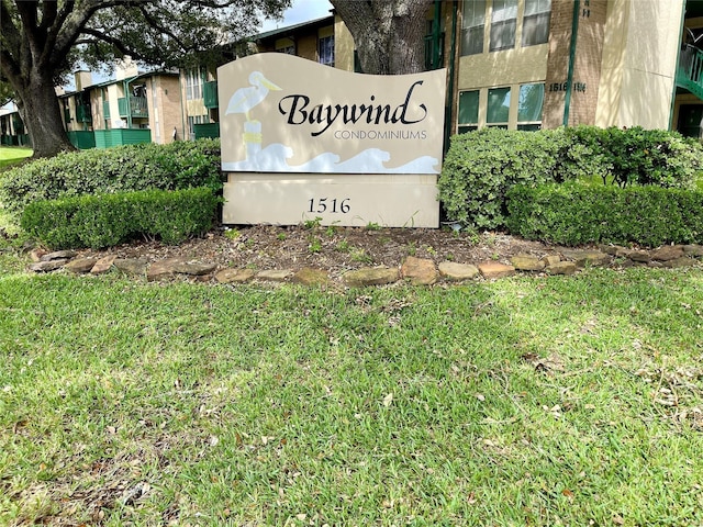 community / neighborhood sign featuring a lawn