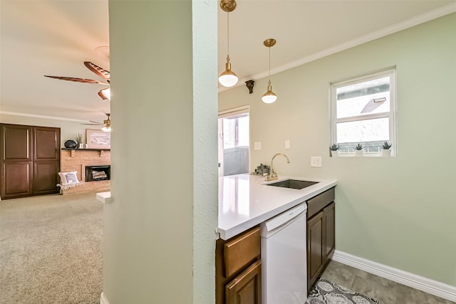 kitchen with dishwasher, baseboards, a fireplace, ceiling fan, and a sink